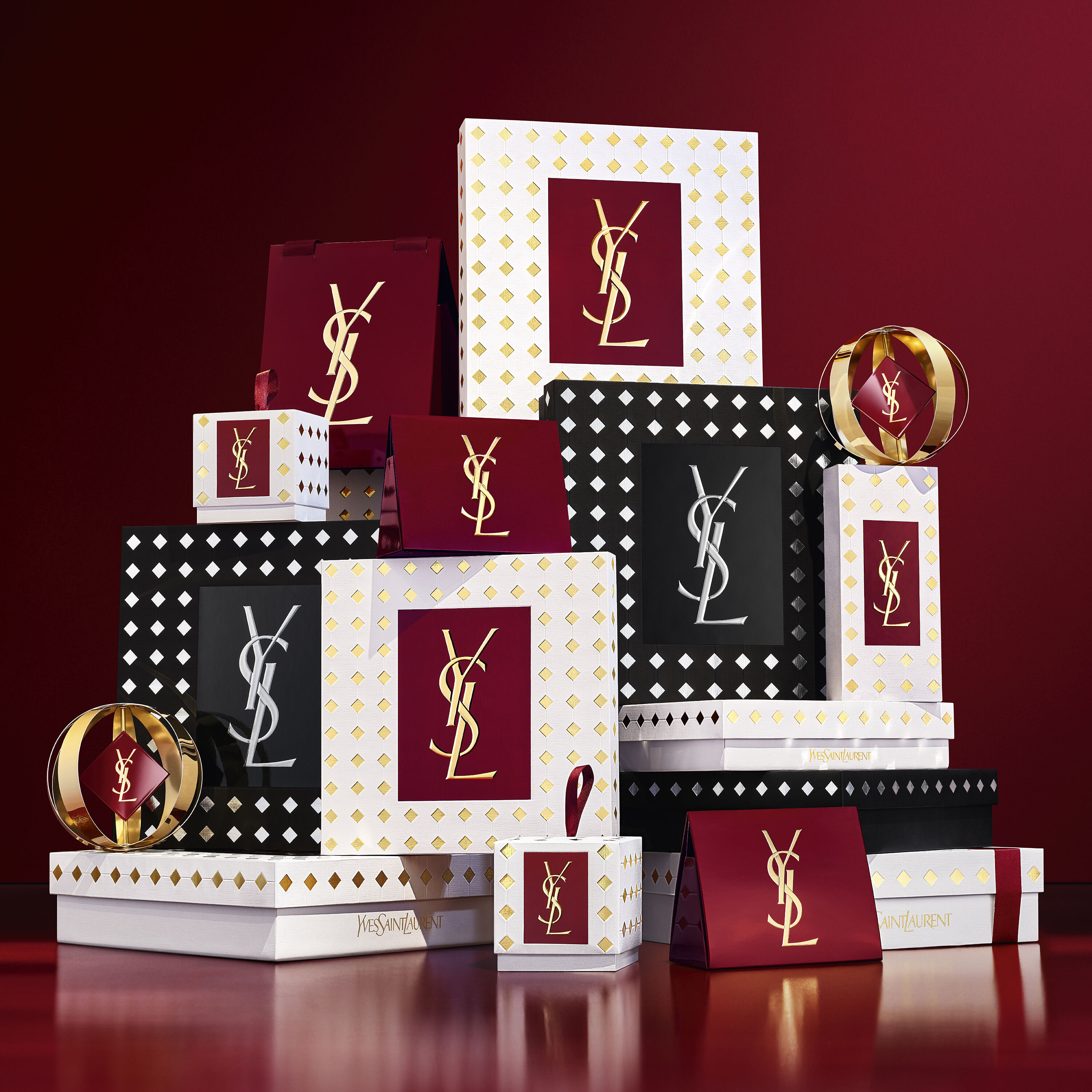 YSL MYSLF Eau de Parfum bottles stacked on black and silver patterned Holiday gift boxes.