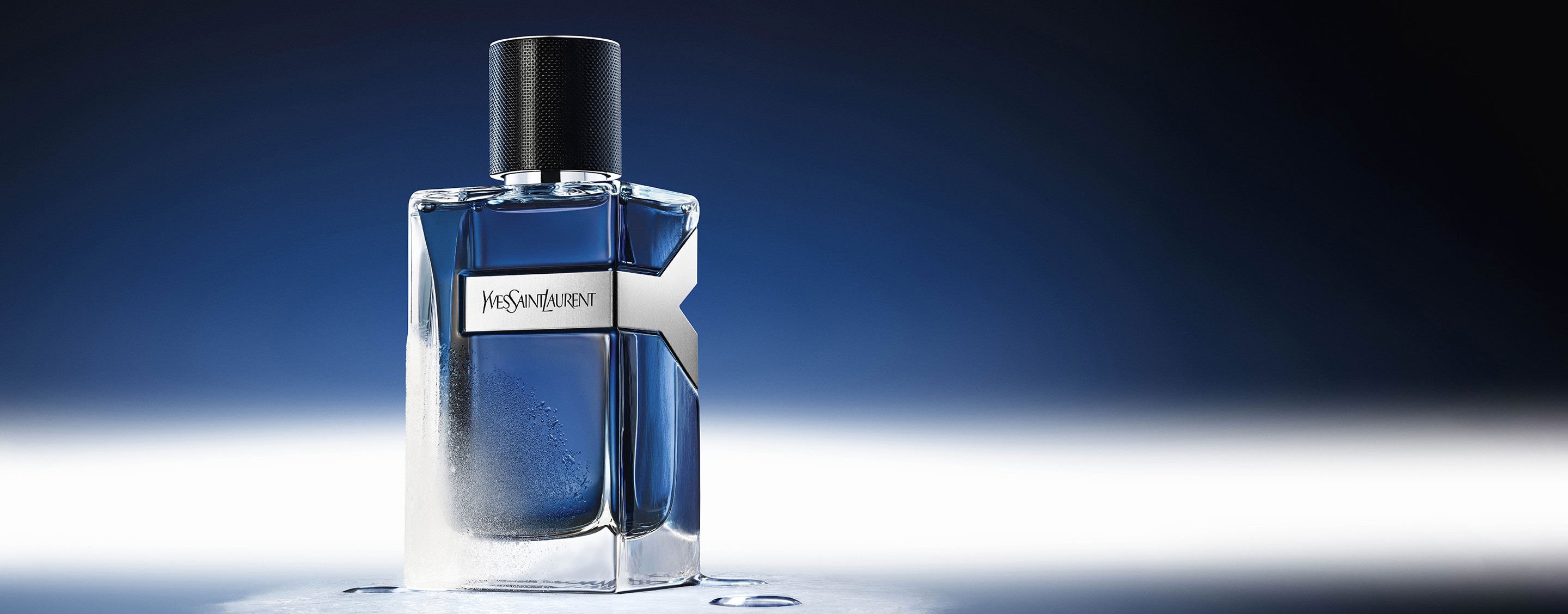 YSL Y Eau de Toilette Intense Iced Cologne 100ml bottle, frosted with water droplets, reflecting a cool blue ambiance.