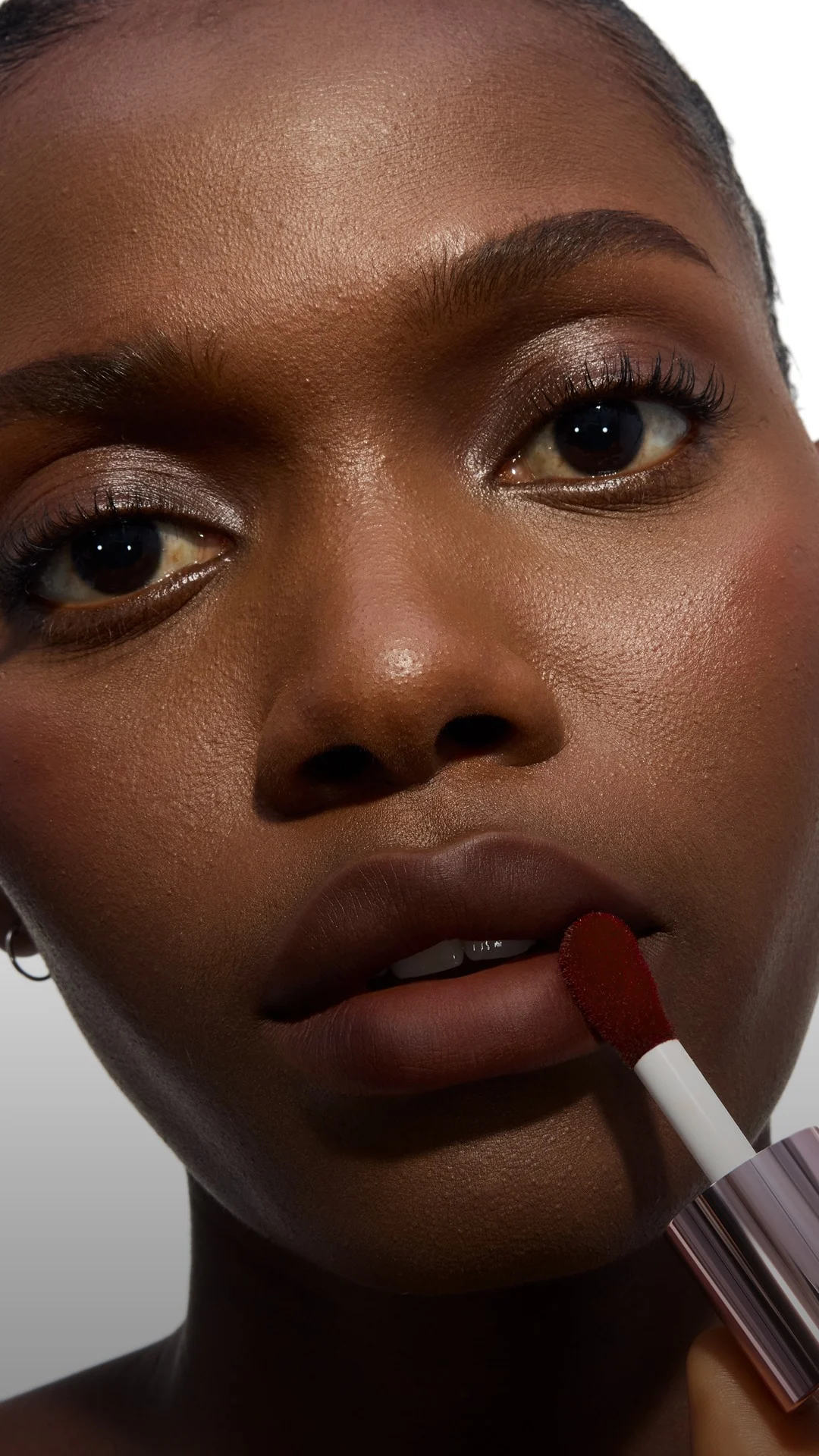 Close-up of a model's cheek wearing the Make Me Blush routine: Powder #15 Chili Crush layered with Cream #65 Strawberry Seduction for a bold, post-workout glow.