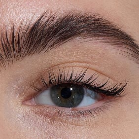  Close-up of an eye with light skin tone, showcasing lengthened lashes from YSL Lash Latex Mascara with level one intensity.