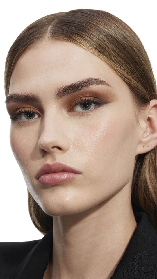 Natalia's gaze captivates, lips adorned with YSL LOVESHINE Plumping Lip Oil Gloss 12 Stardust, product held close.