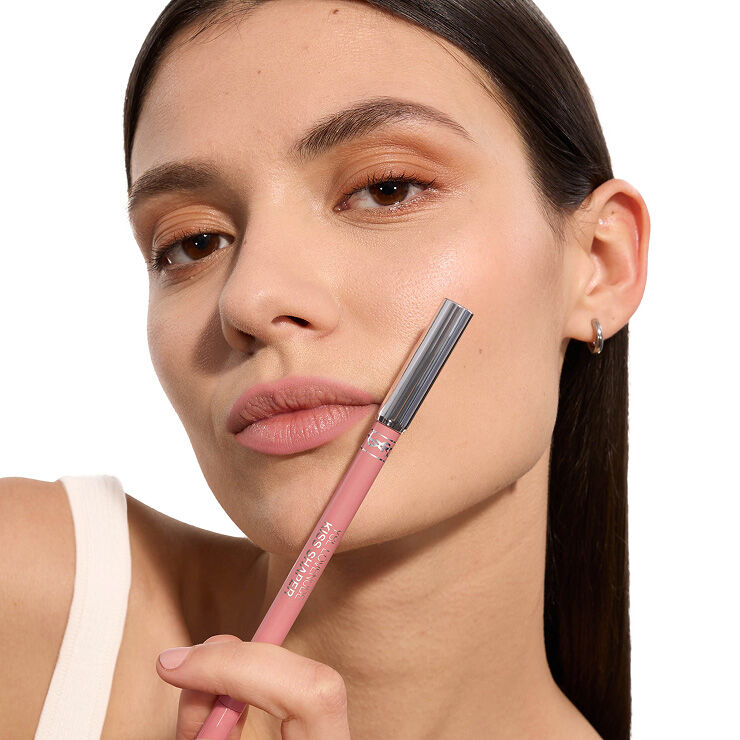 Adrienne wearing YSL LOVENUDE Kiss Shaper, shade 44, on fair skin, holding the product.