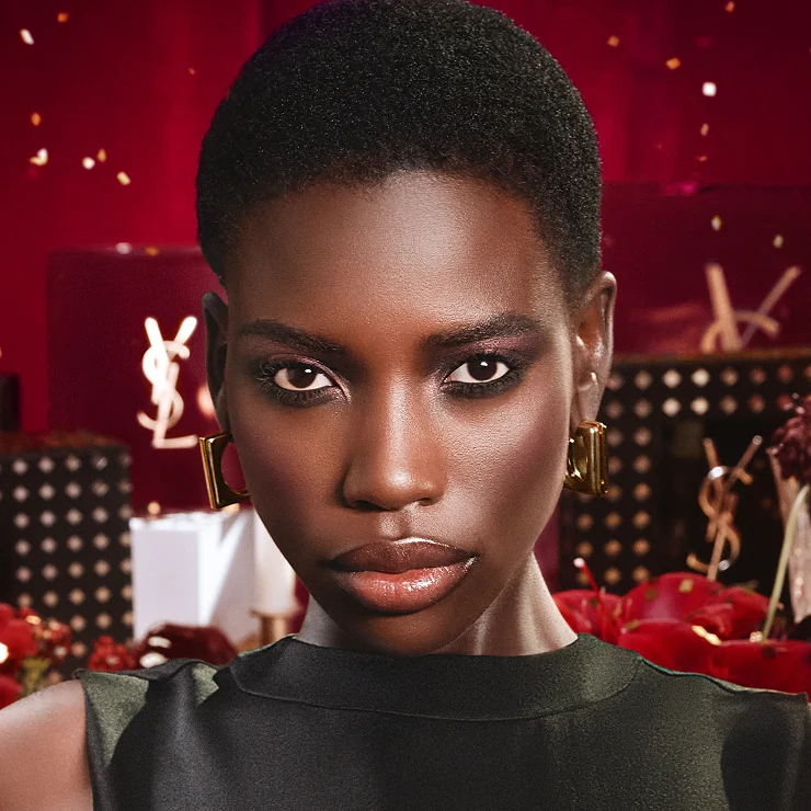 Model in a brown couture dress holding Libre Santal Couture and a matching glazed brown mirror.