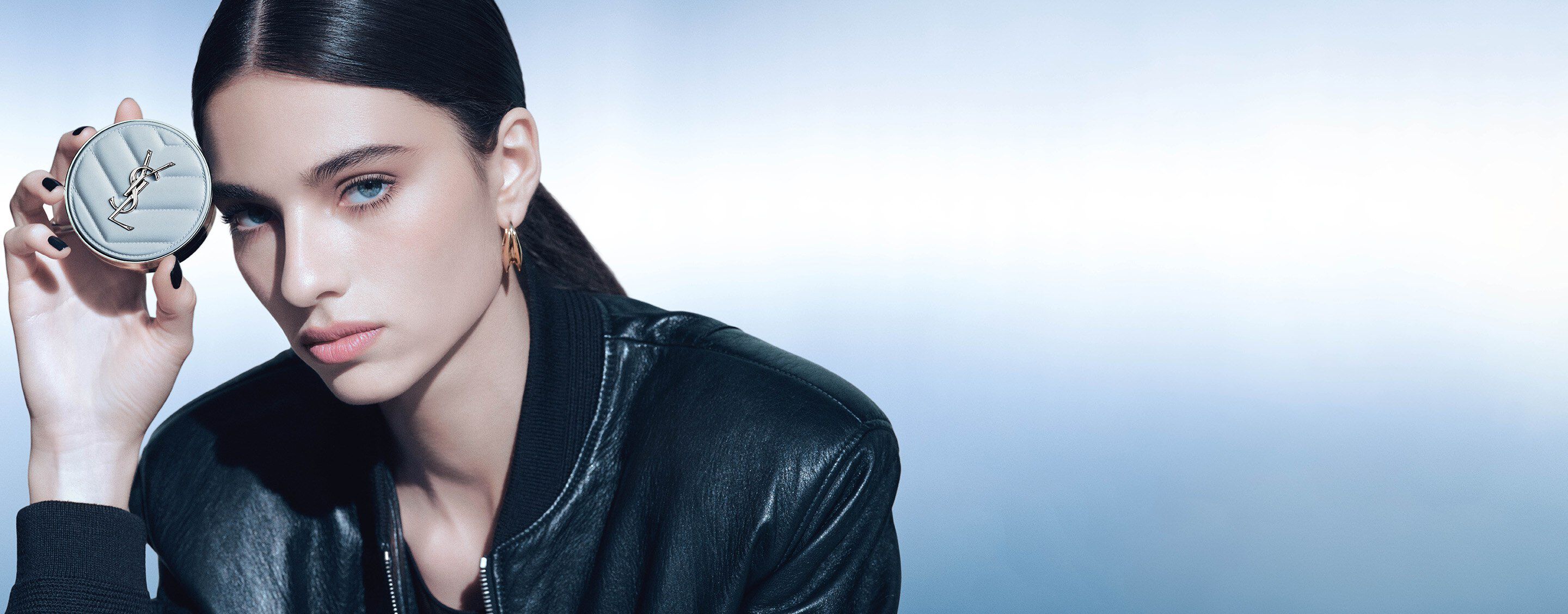 Loli Bahia, YSL Beauty ambassador, holding the YSL All Hours Blur
Cushion, with striking blue eyes.